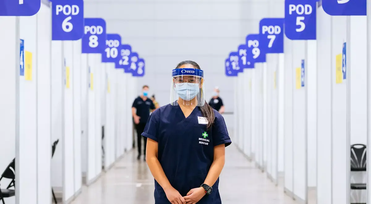 Nurse wearing PPE at vaccination hub min